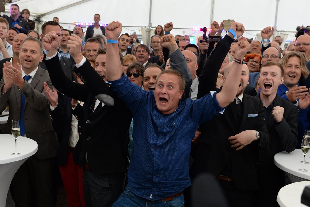 Integrantes y simpatizantes del partido AfD reaccionan luego de conocerse los primeros resultados de la elecciones. (Foto Prensa Libre: AP).