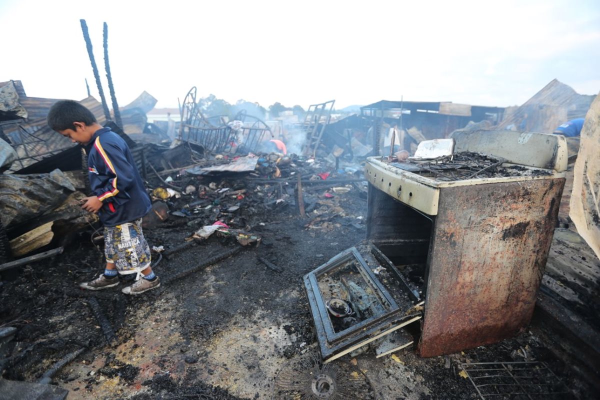 Menor camina entre los escombros que dejó el incendio. (Foto Prensa Libre: Érick Ávila).