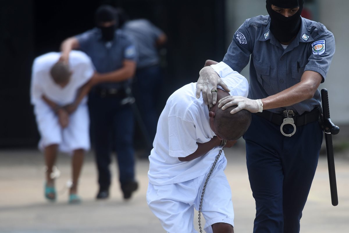 Policías trasladan a dos pandilleros a una cárcel salvadoreña. (Foto Prensa Libre: AFP)