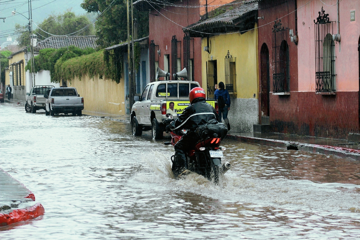 Un motorista pasa por una de las calles anegadas, en Antigua Guatemala, Sacatepéquez. (Foto Prensa Libre: Miguel López)