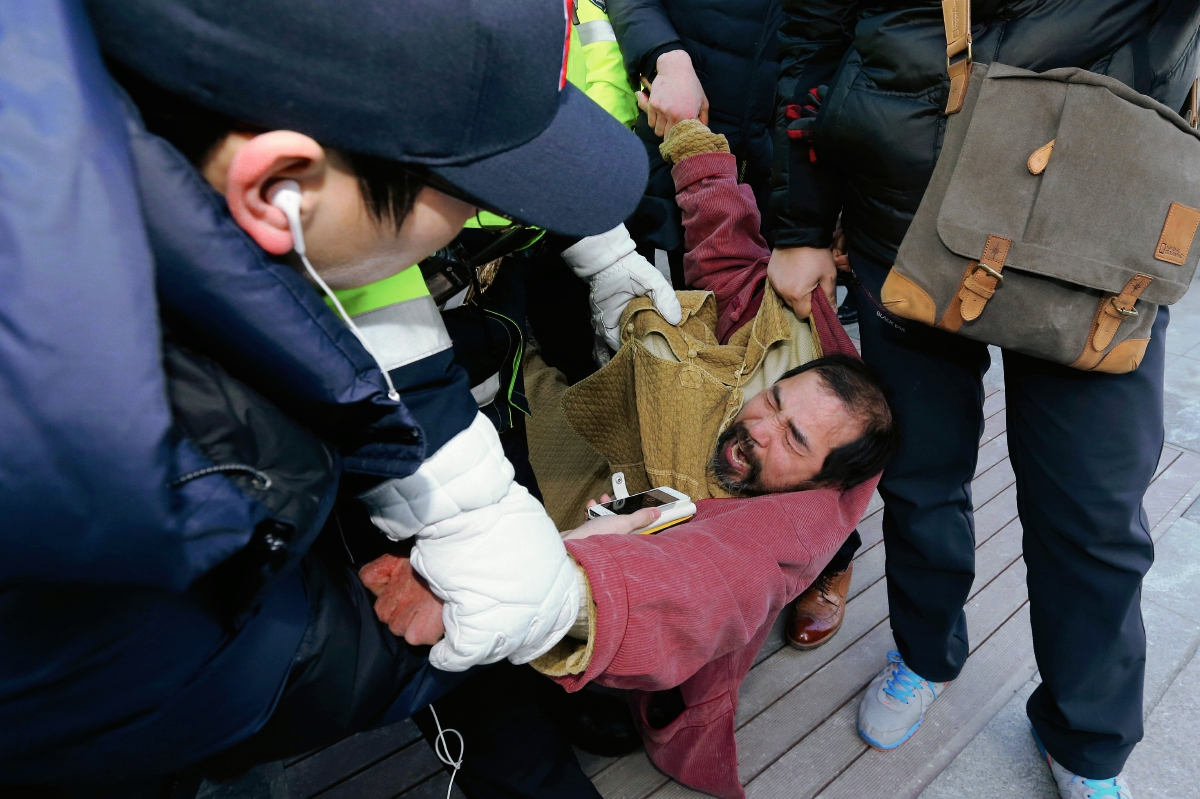 El sospechoso es sometido por la Policía surcoreana después del ataque al embajador Lippert. (Foto Prensa Libre: AFP)