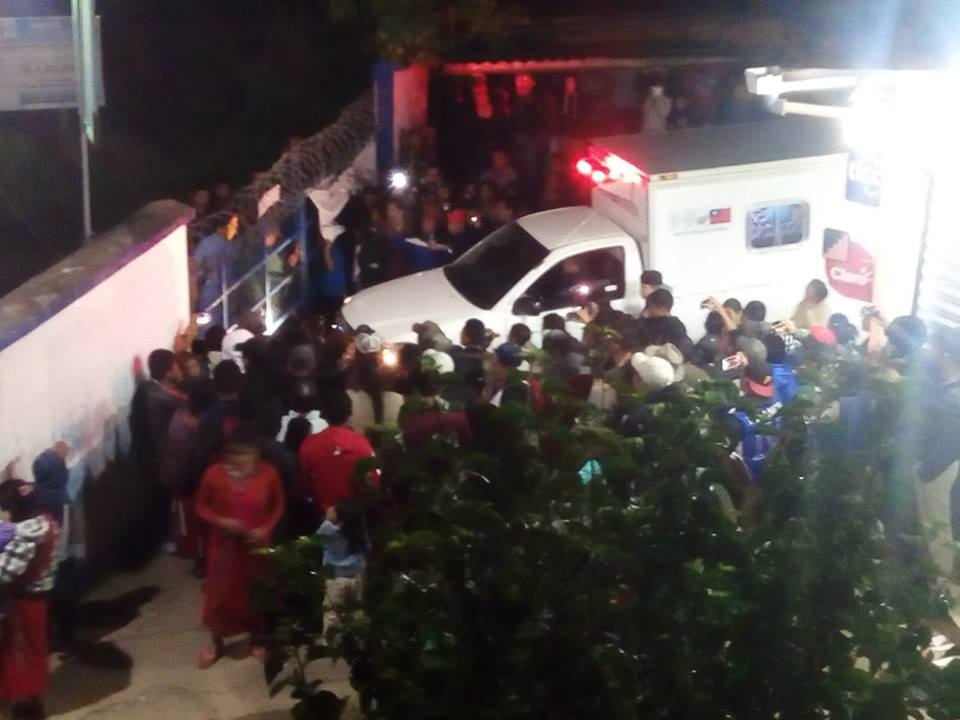 Vecinos de Cipresales, Nebaj, Quiché, se aglomeran frente al Hospital Nacional, a donde llevaron a una mujer y sus dos hijos y al agresor de estos, a quien querían linchar. (Foto Prensa Libre: Cortesía)