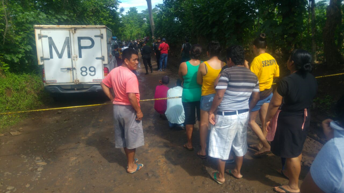 Curiosos observan en el camino de terracería donde fueron hallados los cuerpos de una mujer de 30 años aproximadamente y su bebé, de 2. (Foto Prensa Libre: Rolando Miranda)