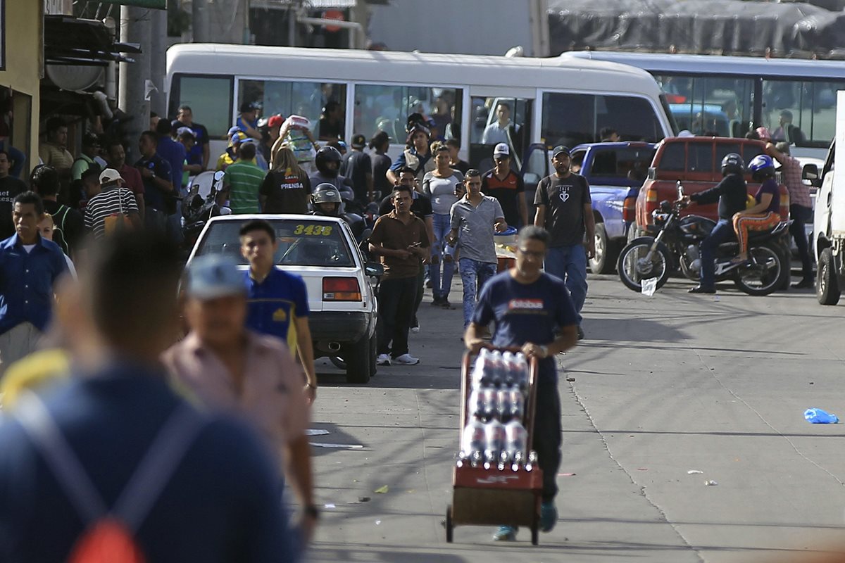 Ciudadanos hondureños caminan a sus trabajos, por paro de transporte que afecta a varios departamentos de Honduras. (Foto Prensa Libre: EFE)