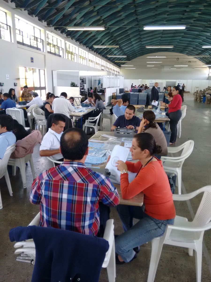 Personas no videntes transcriben al braile los nombres de los partidos políticos en las papeletas celestes, para diputados distritales. (Foto Prensa Libre: Manuel Hernández)