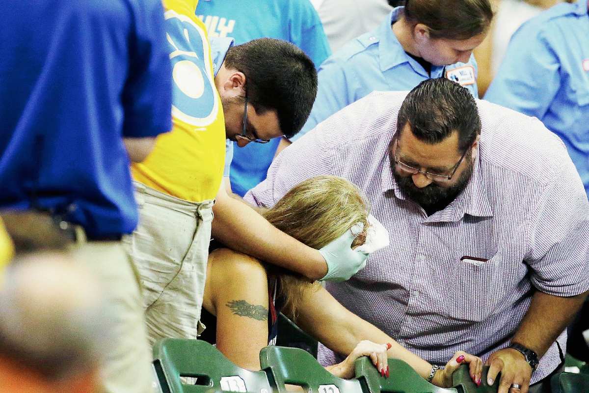 La aficionado fue atendida en luego de recibir un fuerte pelotazo. (Foto Prensa Libre: AP)