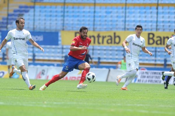 Carlos Ruiz, de Municipal, conduce el balón y es perseguido por los jugadores de Comunicaciones en la final del Clausura 2014. (Foto Prensa Libre: Francisco Sánchez)