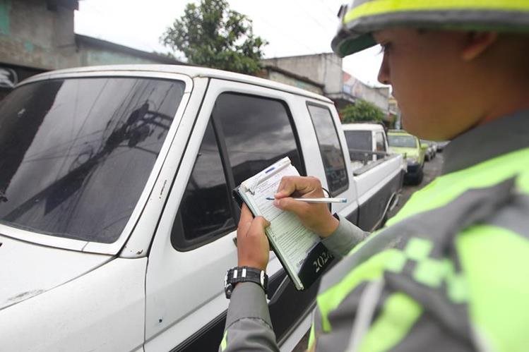 Una agente de la PMT de la Ciudad de Guatemala impone una multa al conductor de un picop. (Foto Prensa Libre: (Hemeroteca PL)