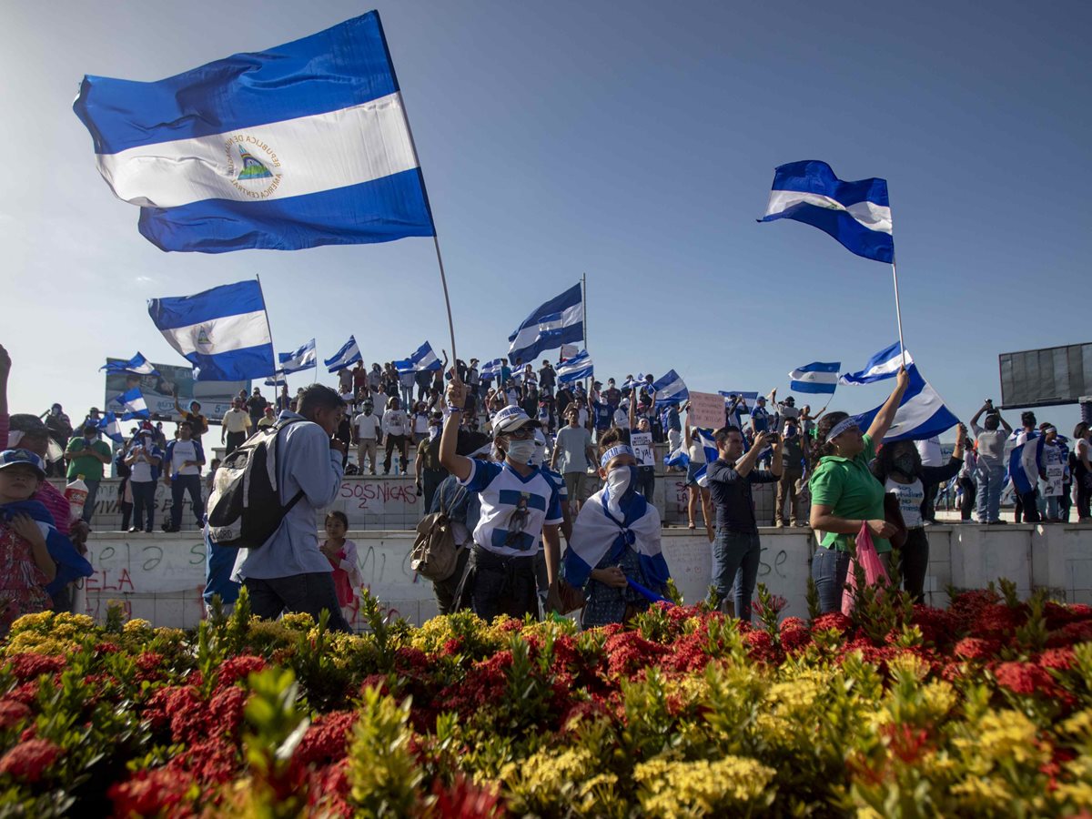 Varios jóvenes con banderas de Nicaragua participan la marcha en Managua para exigir libertad de "presos políticos". (EFE)