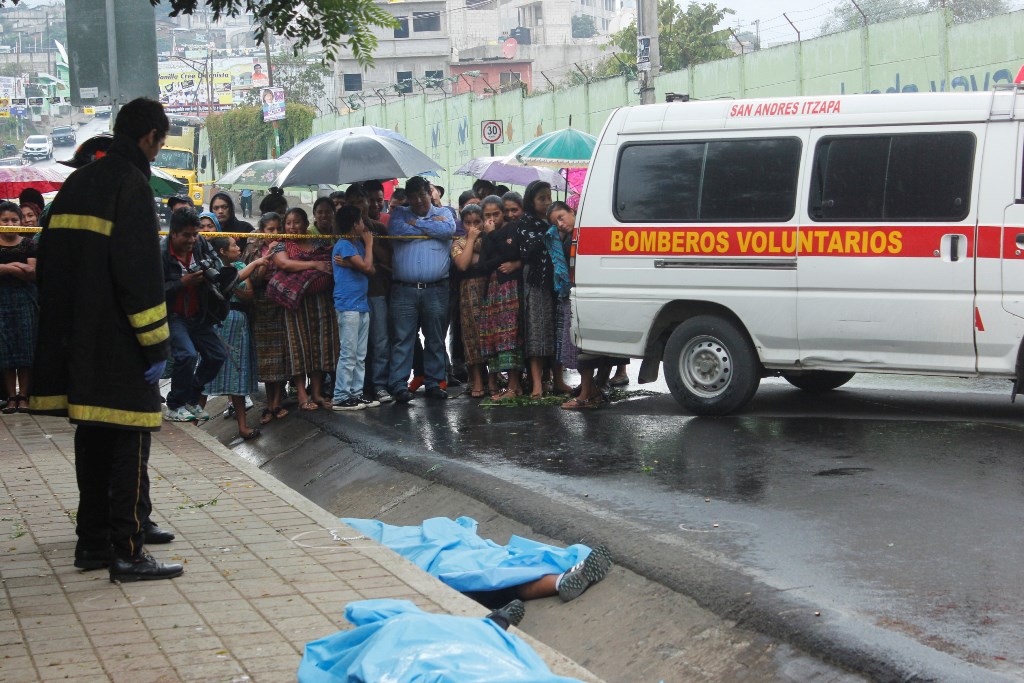 Vecinos observan cadáveres de pareja, en la cabecera de Chimaltenango. (Foto Prensa Libre: Víctor Chamalé)