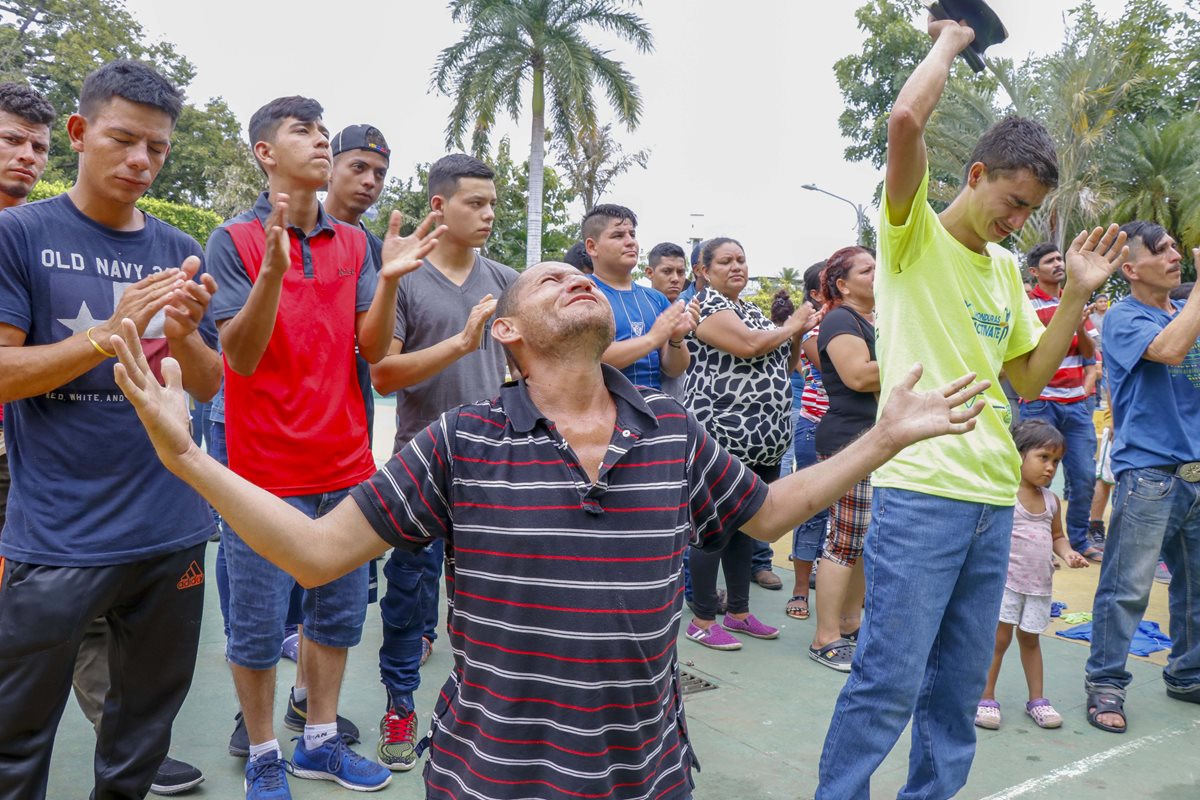 Migrante hondureño ora antes de dirigirse hacia la frontera con México