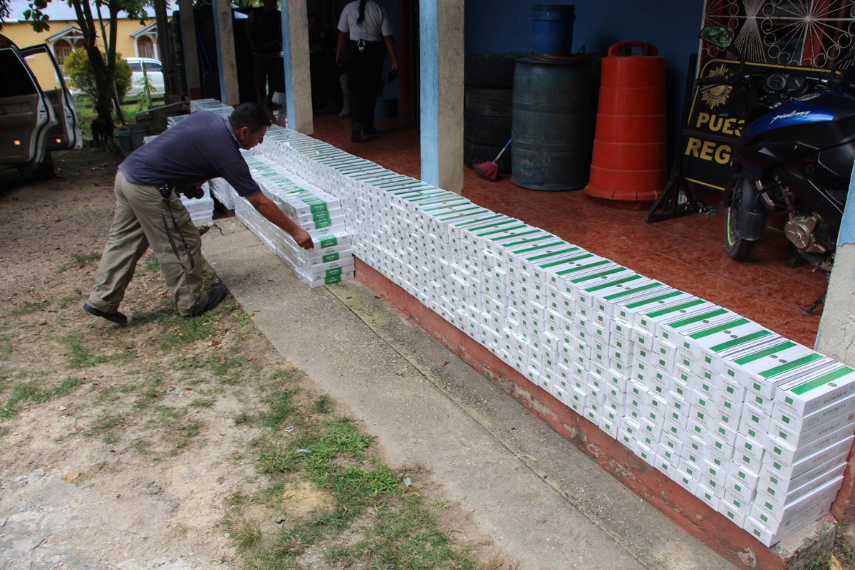 Un agente de la PNC contabiliza cigarrillos decomisados en El Chal, Petén. (Foto Prensa Libre: Walfredo Obando)