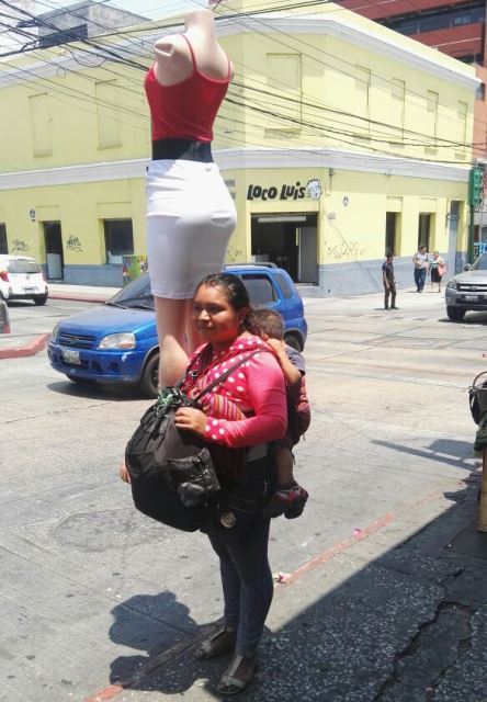 Juana Velásquez carga un maniquí para exhibir los trajes para dama que vende en la zona 1 capitalina. (Foto Prensa Libre: Edwin Pitán)