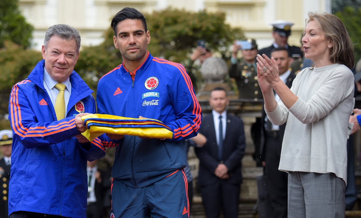 El presidente colombiano Juan Manuel Santos junto a Radamel Falcao durante la ceremonia que le entregó el pabellón a la selección cafetera. (Foto Prensa Libre: AFP)