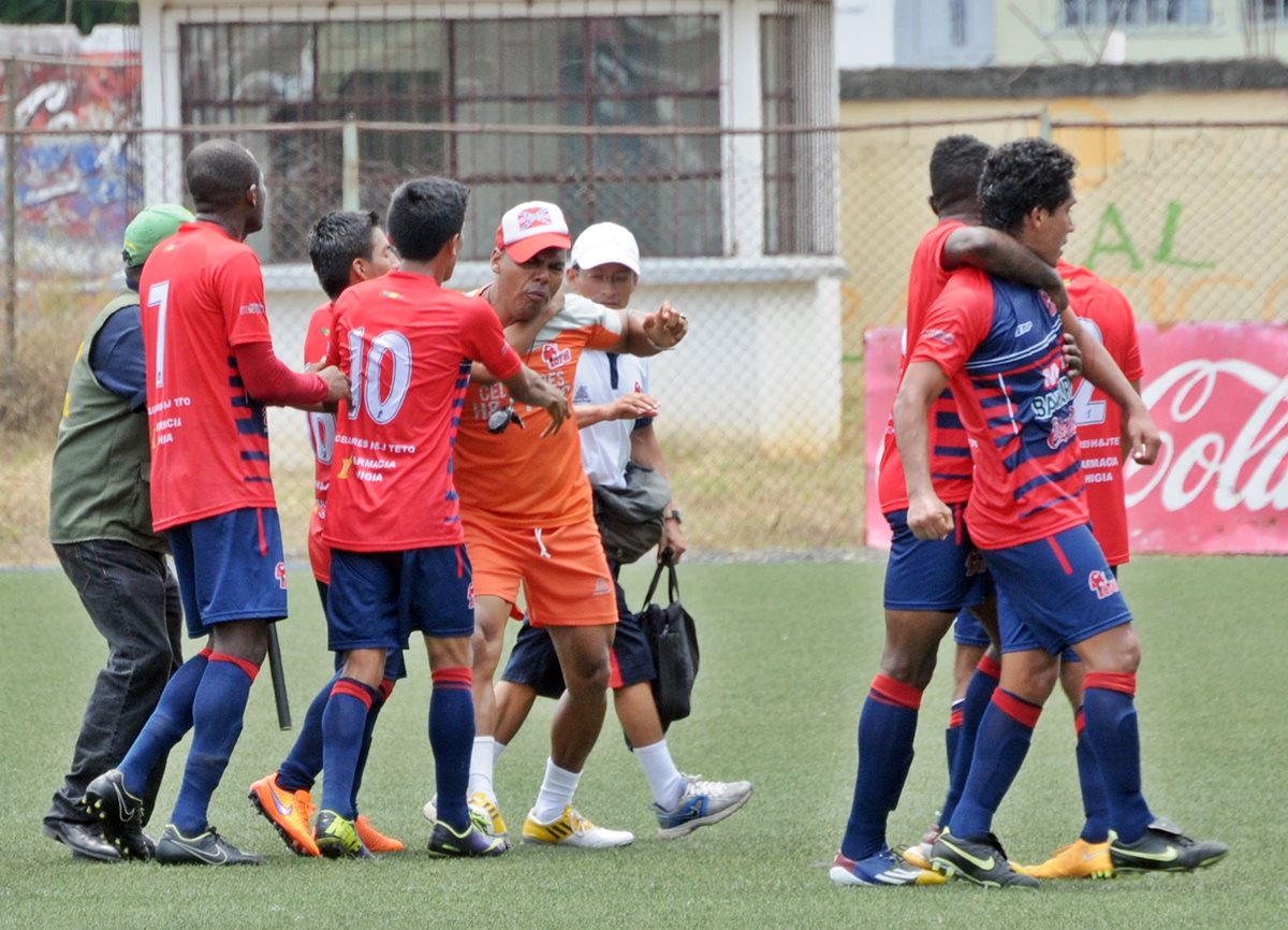 Los jugadores tratan de controlar a Roberto Carlos Valiente luego de la pelea con Juan Carlos Silva. (Foto Prensa Libre: Alexander Coyoy)