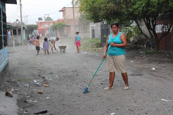 Pobladores, niños y adultos  limpian la calle principal de Tiquisate, Escuintla.