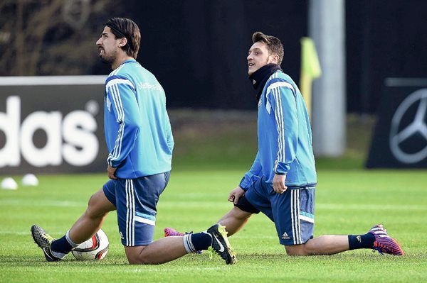 Los centrocampistas de la selección alemana Mesut Özil (d) y Sami Khedira (i) calientan durante un entrenamiento de su equipo en Fráncfort, Alemania, el pasado lunes. (Foto Prensa Libre: EFE).