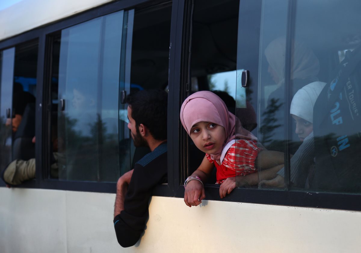 Refugiados y combatientes sirios y sus familias abandonan el antiguo bastión rebelde de Duma. (AFP)