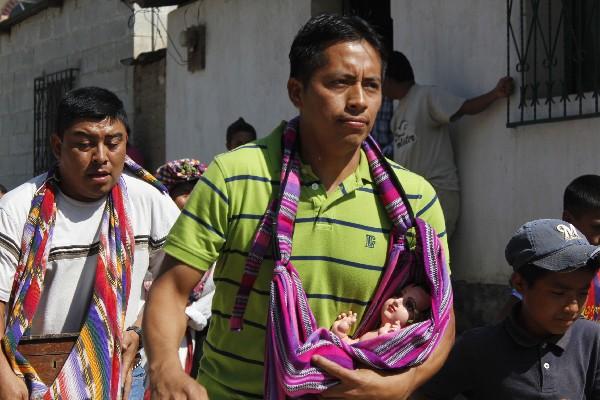 Un cofrade   lleva la  imagen del Niño Dios,   durante tradicional corrida en Rabinal.