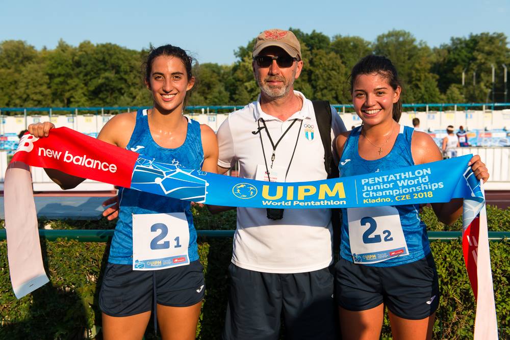 Cabrera y Hernández posan con su entrenador después del oro logrado en relevos femeninos en pentatlón. (Foto UIPM).