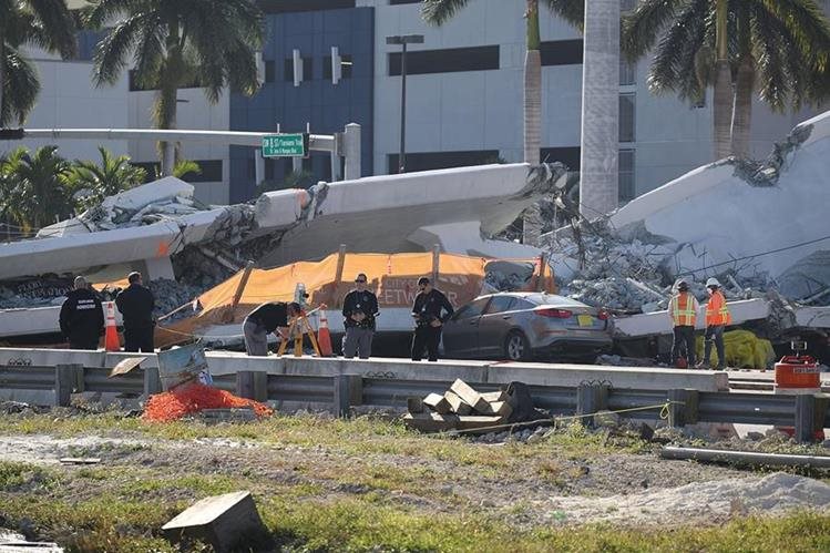 Expertos investigan la escena donde un puente peatonal se derrumbó unos días después de que se construyó en Miami. (AFP).