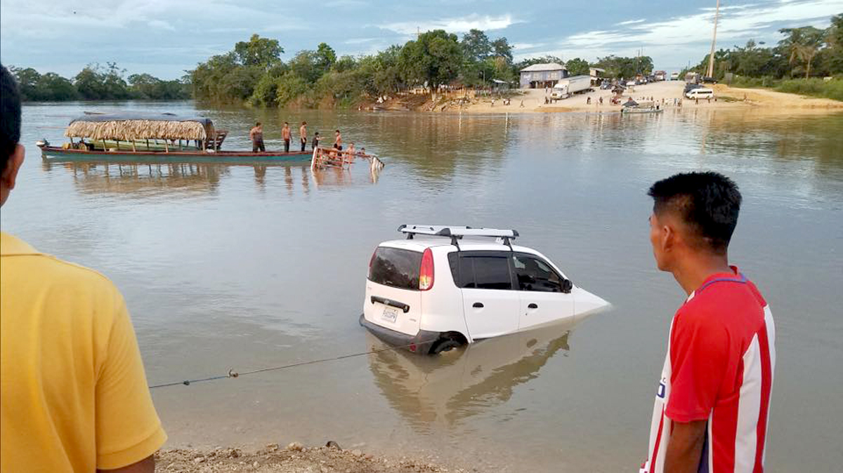 Vecinos sacan del río el taxi en el que viajaban los menores. (Foto Prensa Libre: Dony Stewart).