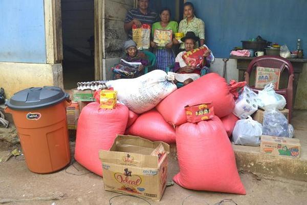 Andrés López y su esposa, Isabel Pérez —sentados—,  reciben víveres comprados con donativos de lectores de Prensa Libre. (Foto Prensa Libre: Édgar Girón)