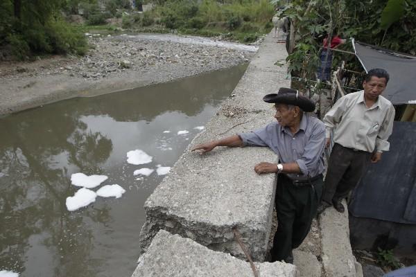 Un vecino muestra los daños  que las correntadas del río Las Vacas han causado en el muro de contención.
