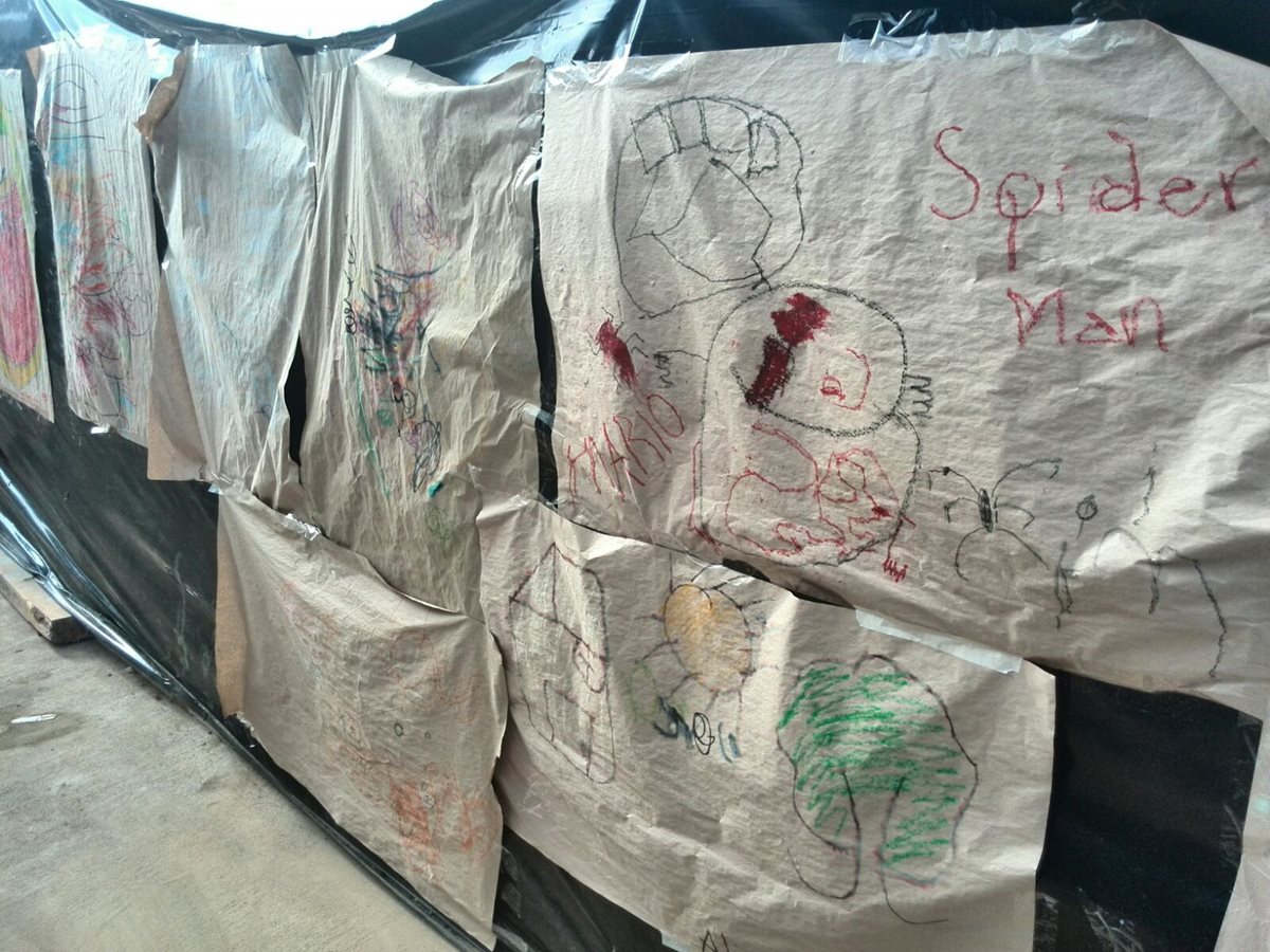 Varios dibujos que hicieron varios niños los volvieron mural en la carpa que sirve de morgue (Foto Prensa Libre: Estuardo Paredes)