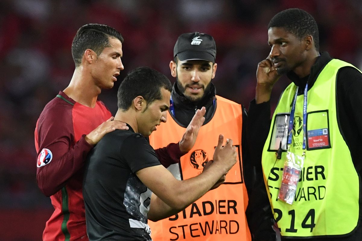 Cristiano le pidió a los guardias de seguridad que esperaran para que el aficionado se tomará la fotografía. (Foto Prensa Libre: AFP)