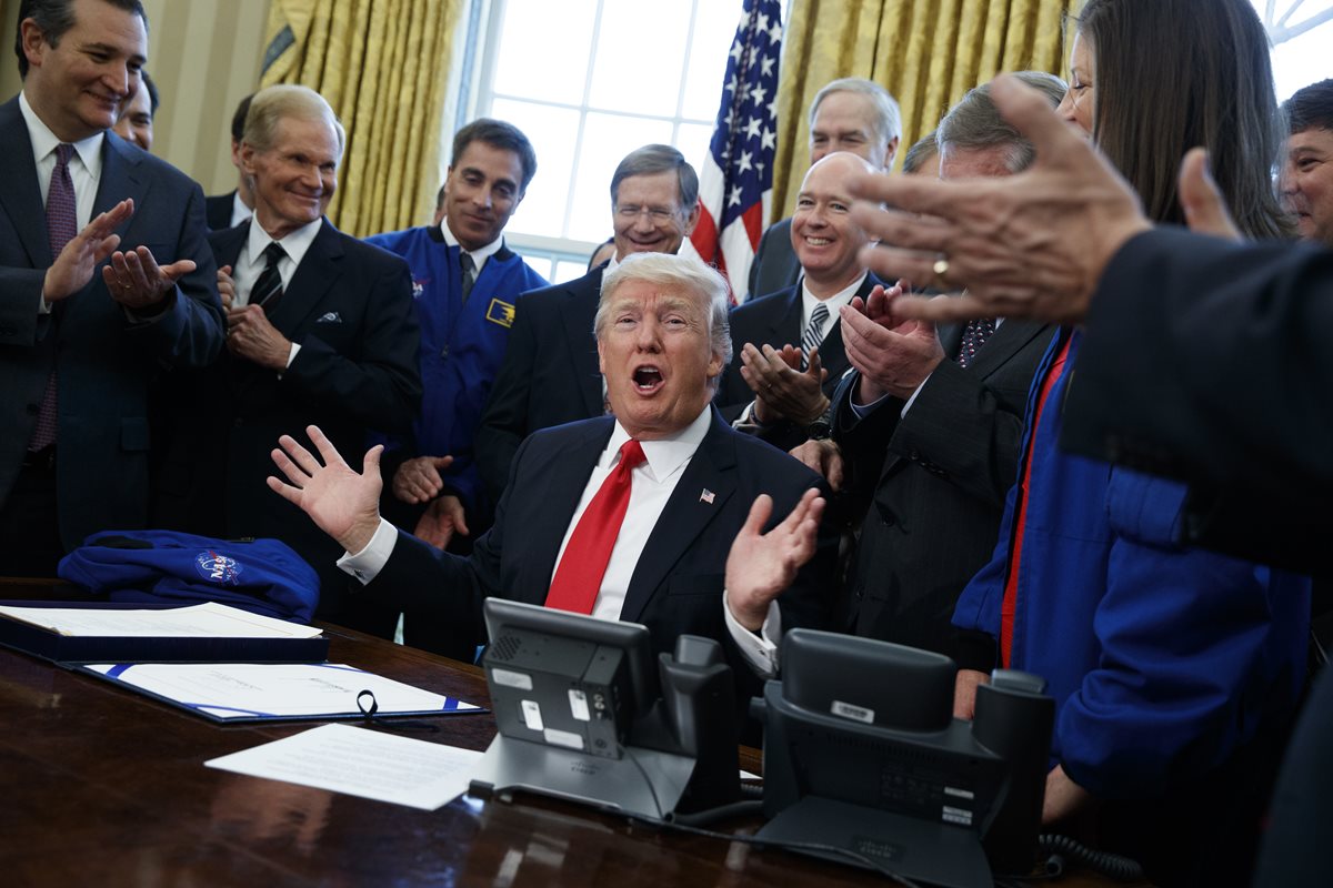 Funcioanarios celebran después de que Trump firma incremento de presupuesto para la Nasa. (Foto Prensa Libre: AP)