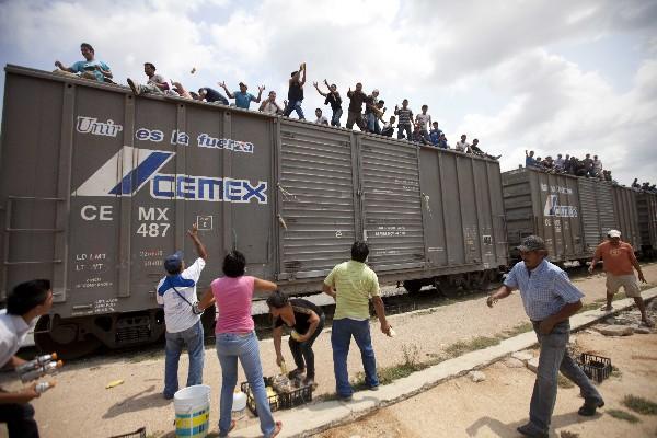 Mujeres apoyadas por hombres lanzan <span class="hps">comida</span> <span class="hps">a los inmigrantes</span> <span class="hps">que viajaban en</span> <span class="hps">el</span><span class="hps"></span> <span class="hps">tren en México que se dirigía</span> <span class="hps"></span> <span class="hps">hacia</span><span class="hps atn"> EEUU. (ARCHIVO)</span><span></span>