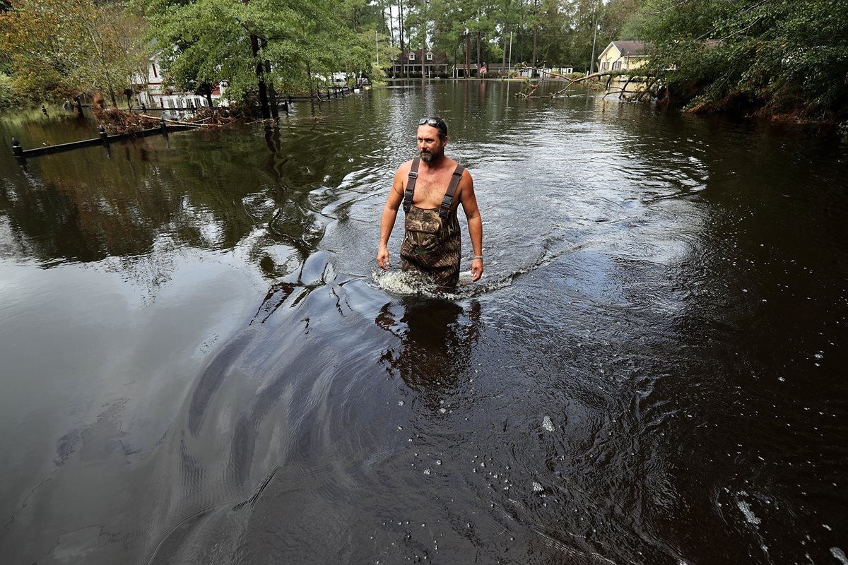 Un poblador camina cerca de su casa, en Spring Lake, Carolina del Norte. (Foto Prensa Libre: AFP)