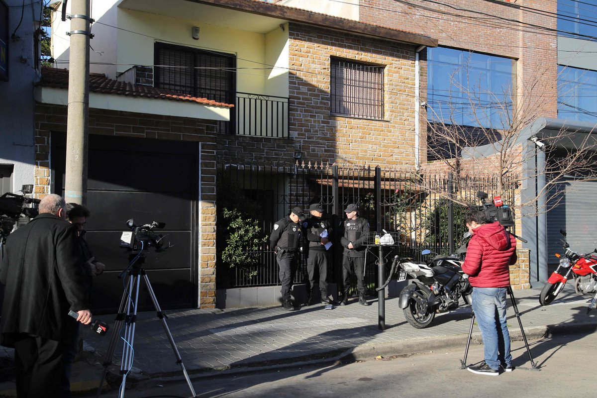 Las autoridades frente a la casa de Óscar Centeno, chofer de un alto funcionario del Ministerio de Planificación escribió durante más de una década cómo transportaba en su auto bolsas con millones de dólares que empresarios destinaban a miembros del kirchnerismo, entre ellos, supuestamente, el matrimonio presidencial.(AFP)