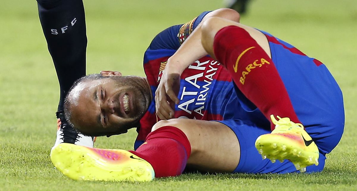 Iniesta quedó tendido en el césped por un golpe durante el partido contra el Sevilla. (Foto Prensa Libre: EFE)