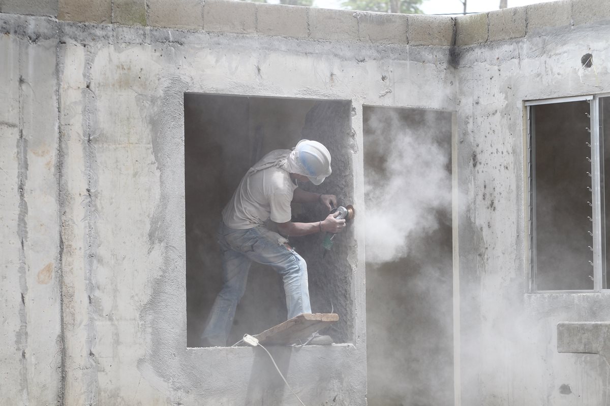 Albañil trabajo en retoques estéticos de viviendas que se terminaron de fundir la semana pasada. (Foto Prensa Libre: Erick Ávila)