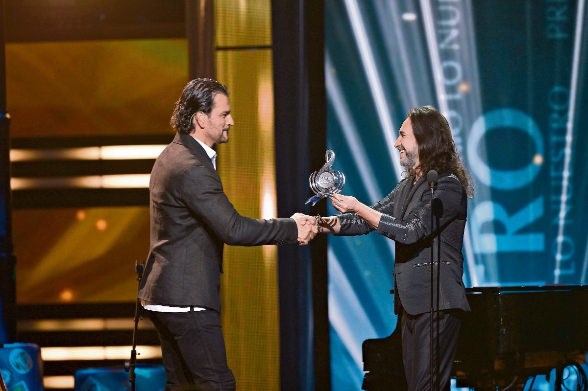 Marco Antonio Solís le entregó el galardón a Ricardo Arjona. (Foto Prensa Libre: AFP)