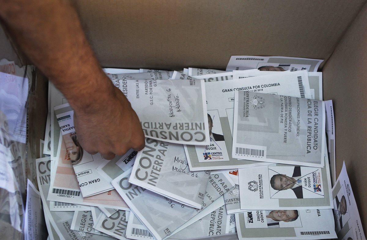 Un hombre realiza el conteo de las papeletas para las dos consultas interpartidistas durante las elecciones legislativas. (EFE).