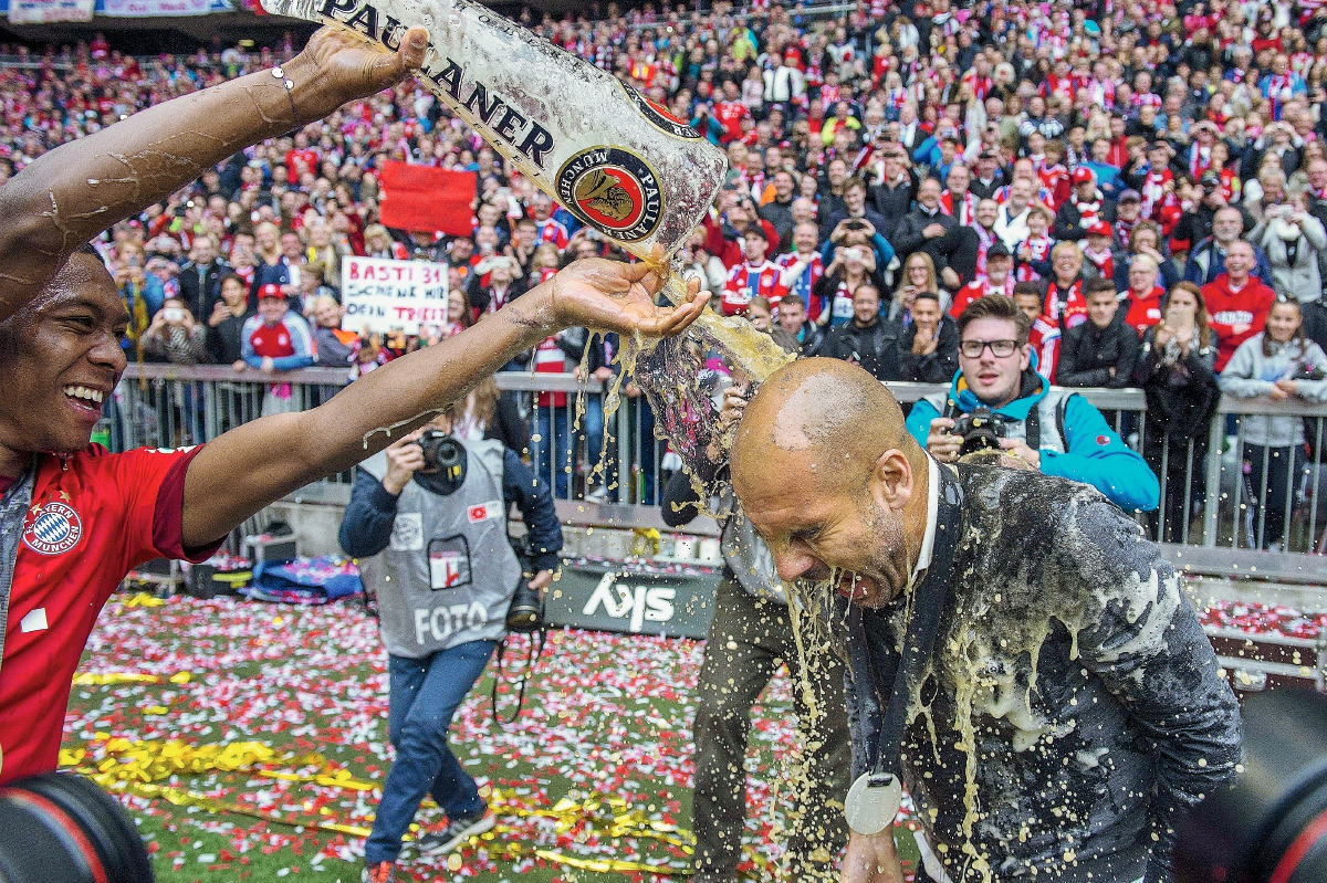 Aunque Pep Guardiola trató de escapar no pudo evitar el tradicional baño de cerveza. (Foto Prensa Libre: AFP)