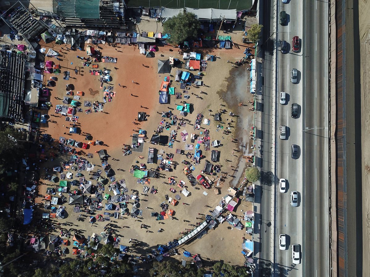 Vista aérea que muestra a migrantes centroamericanos hoy, en un albergue habilitado en la Unidad Deportiva Benito Juárez, en la ciudad de Tijuana, México.