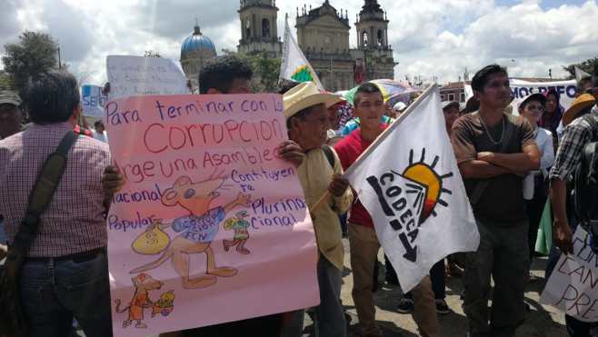 Manifestantes en la Plaza de la Constitución muestran pancartas en rechazo a la corrupción.