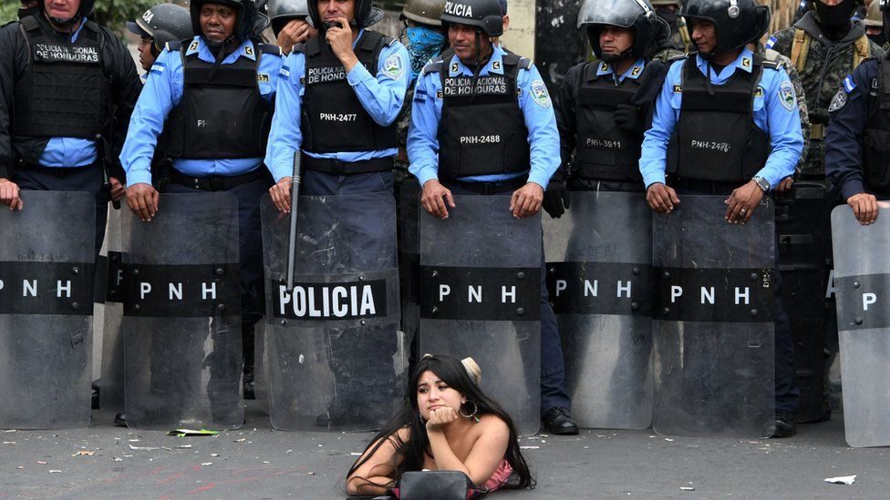 Una manifestantes se acuesta frente a la policía en una protesta contra la reelección del presidente Juan Orlando Hernández en Honduras. GETTY IMAGES
