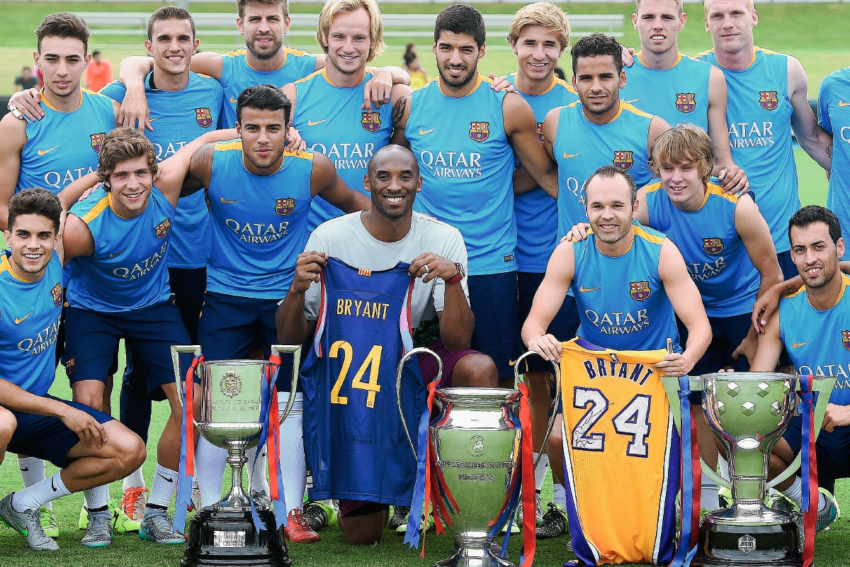 Los jugadores del Barcelona junto con Kobe Bryant y los trofeos del tricampeonato. (Foto Prensa Libre: AFP)