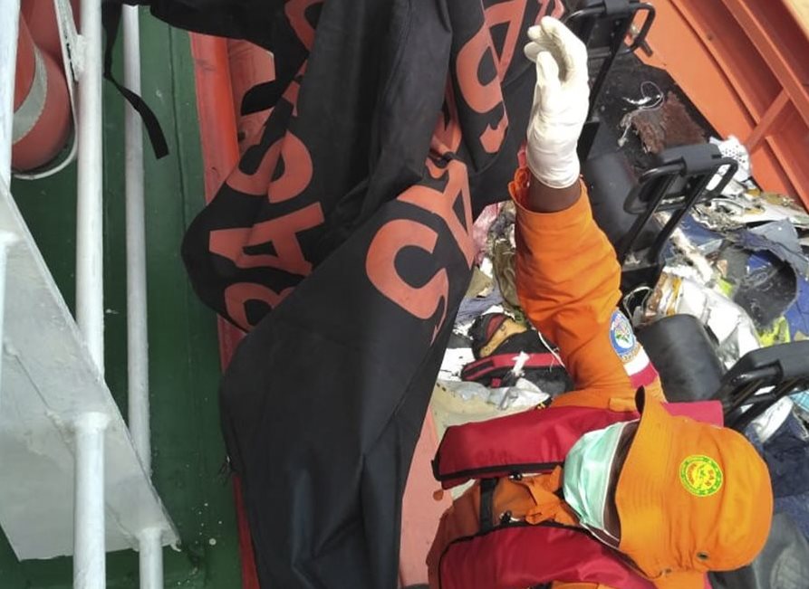 Un socorrista ayuda a rescatar los restos de una de las víctimas del accidente aéreo que se precipitó a gran velocidad al mar de Java. (Foto Prensa Libre: EFE)