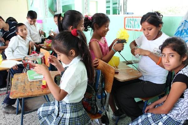 Un grupo de niños  transforma los desechos en adornos para el hogar.