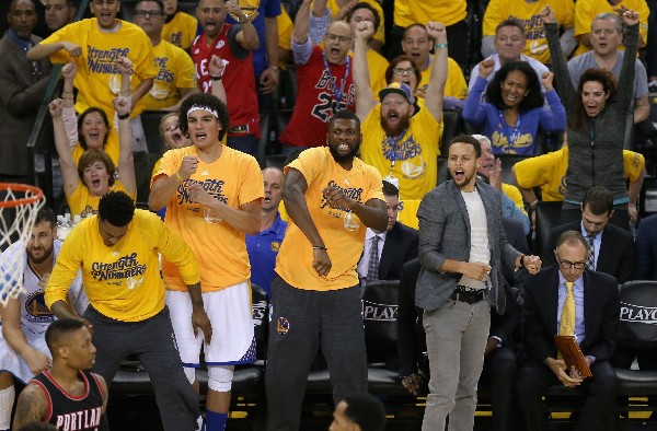 El jugador de los Warriors Stephen Curry, derecha, reacciona tras una jugada en la serie con Portland Trail Blazers. (Foto Prensa Libre: AFP).