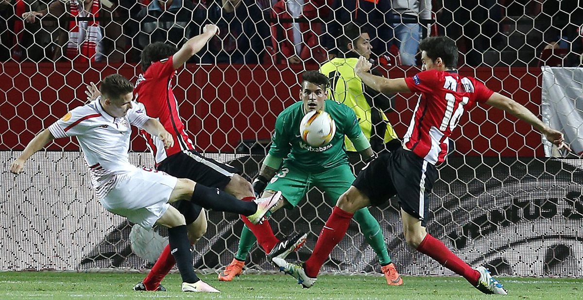 El delantero francés del Sevilla, Kevin Gameiro (i), golpea el balón ante los defensas y el guardameta del Ath de Bilbao. (Foto Prensa Libre: EFE)