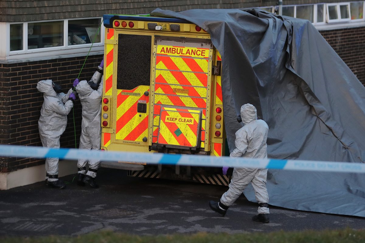 Efectivos de seguridad cubren una ambulancia con una lona alquitranada para ser retirada por personal militar en el Hospital Salisbury District en Salisbury, sur de Inglaterra. (AFP).