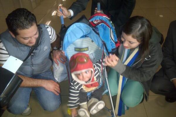 Santiago Haider Palencia y sus padres son captados por fotógrafos de Prensa en el aeropuerto La Aurora. (Foto Prensa Libre: Juan Manuel Castillo)