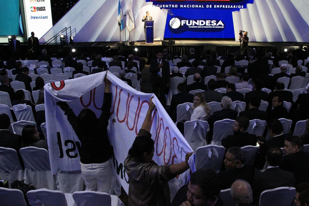 Personas asistentes al Enade 2017 mostraron una manta durante la exposición del presidente Jimmy Morales. (Foto Prensa Libre: Carlos Hernández).